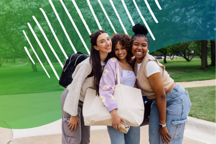 Three young adults smiling and hugging